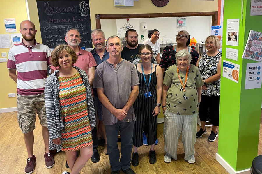 a large group of volunteers standing indoor