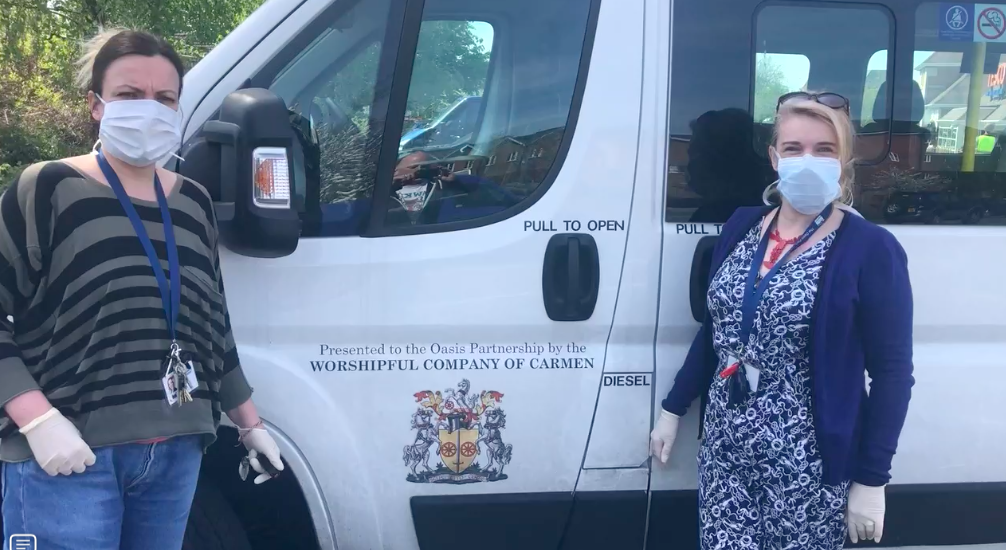 two supporters, wearing covid face masks next to Recovery Van Covid Homeless Outreach